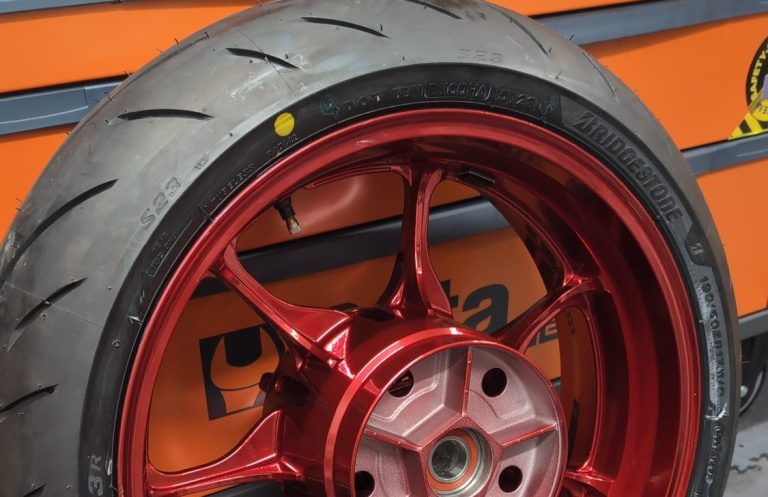 Close-up of a motorcycle exhaust fitted to a racing bike on a stand. With no rear wheel fitted.