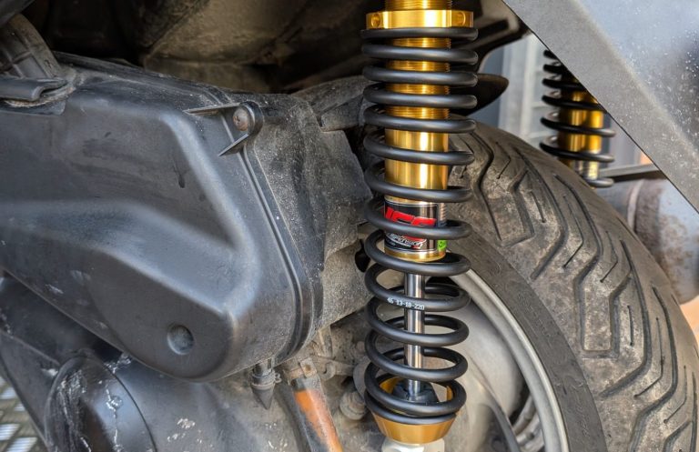 Close-up of a motorcycle's rear suspension and tyre.