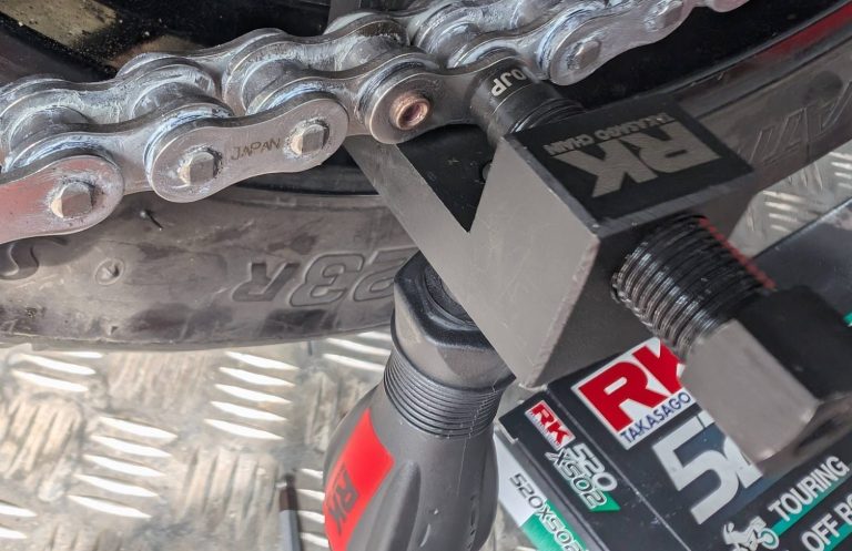 A motorcycle chain tool riveting a new chain.